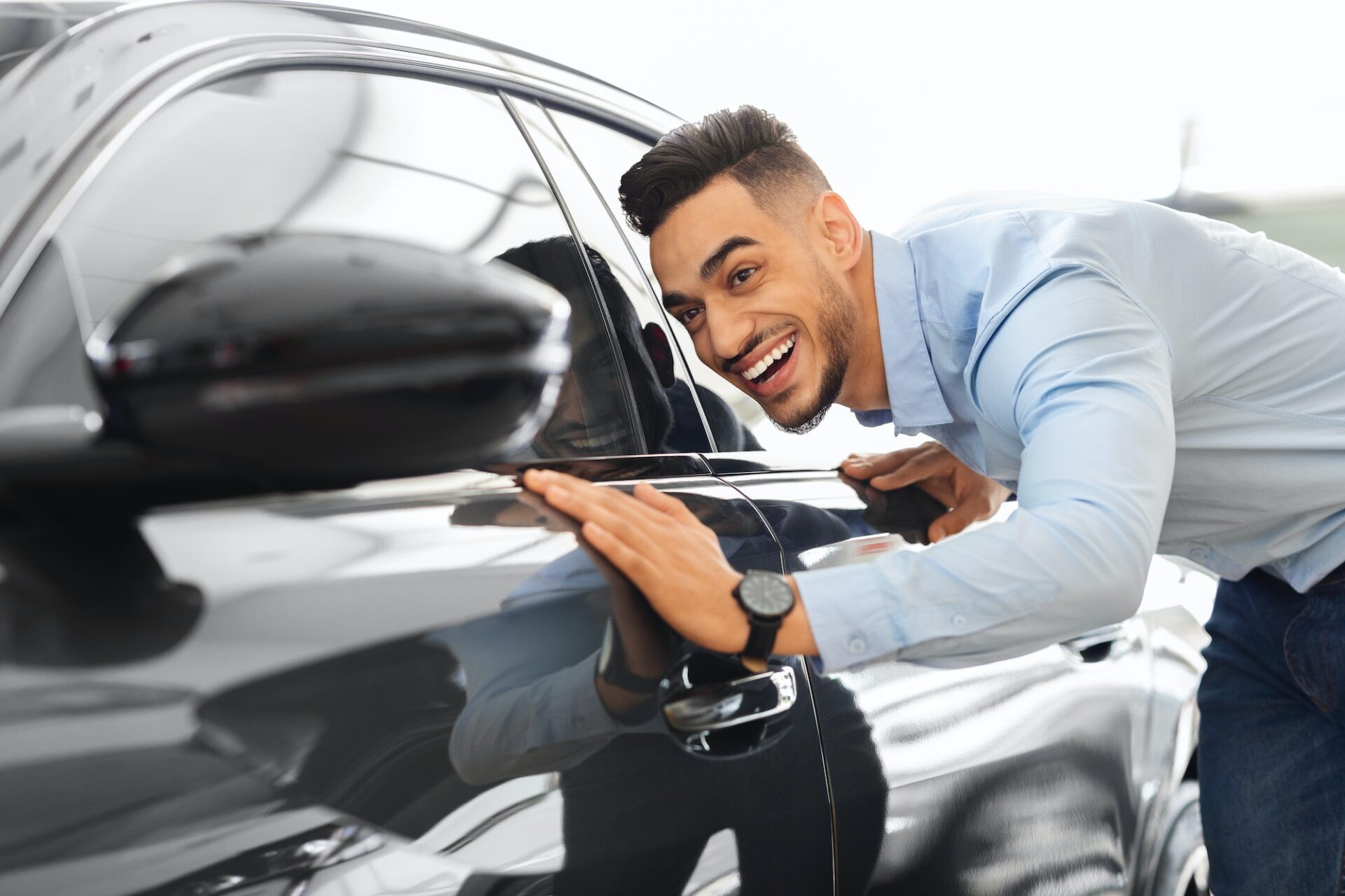 Handsome arab man buying new car, checking surface